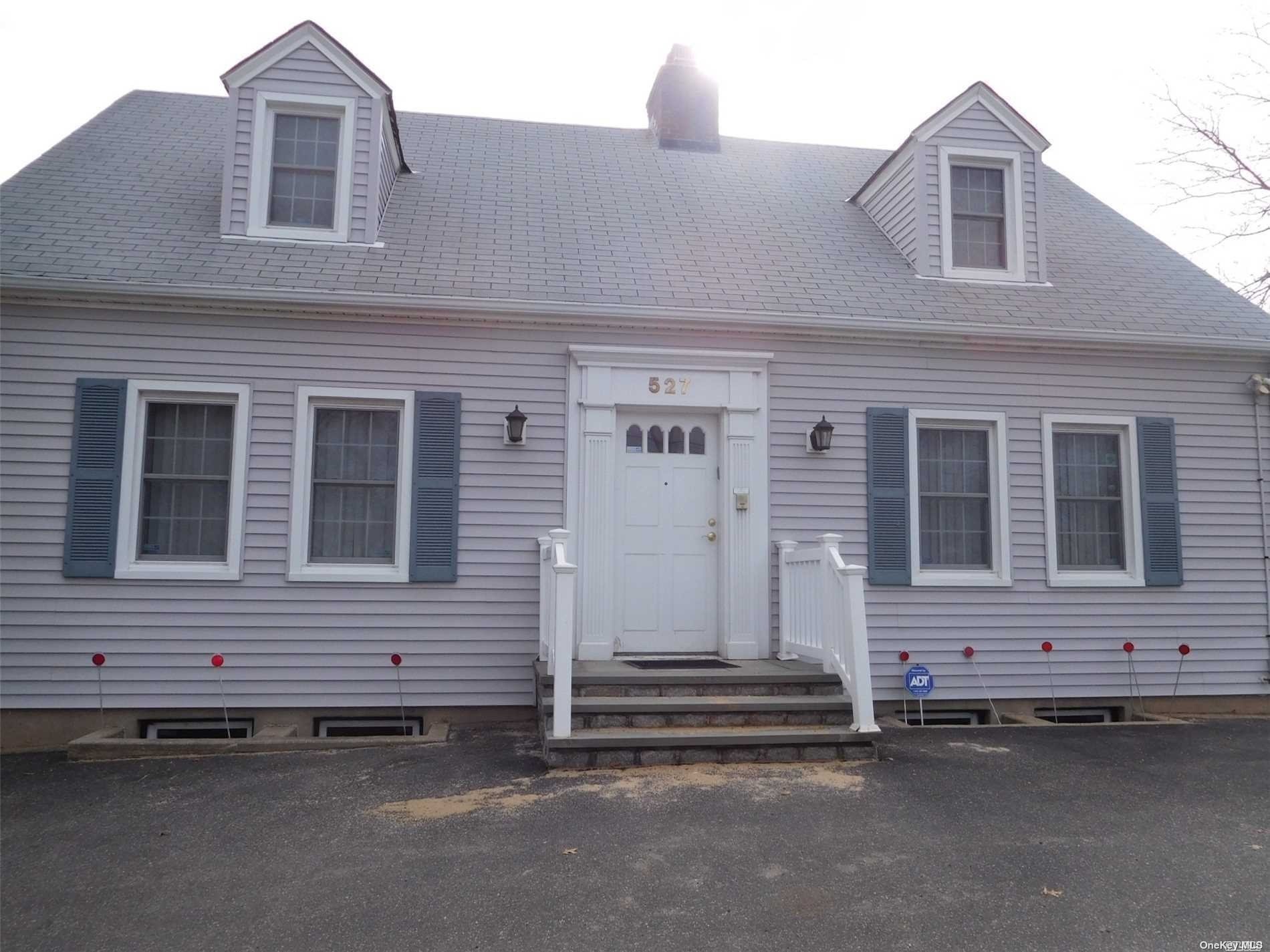 a front view of a house with a road