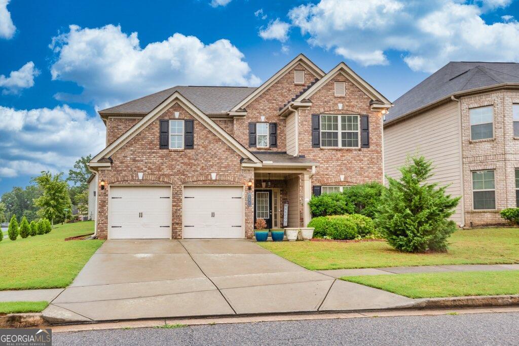 a front view of a house with a yard and garage