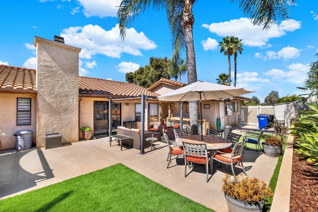 a view of a patio with a table and chairs under an umbrella