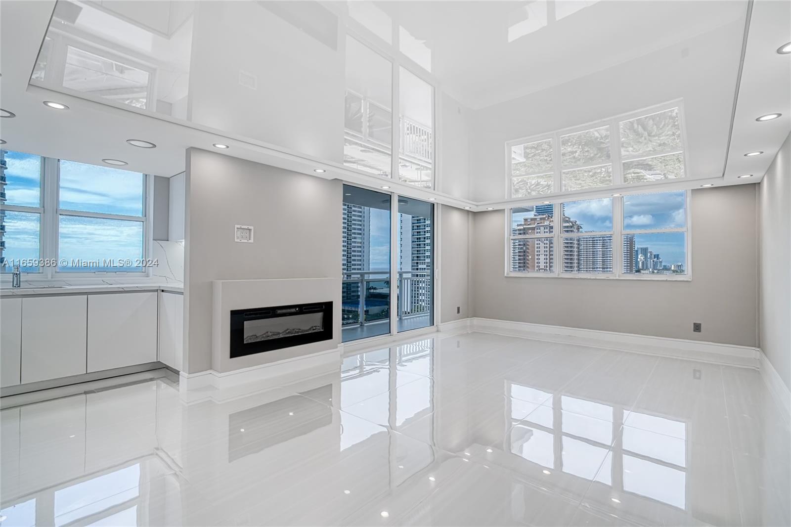 a view of an empty room with a fireplace and windows