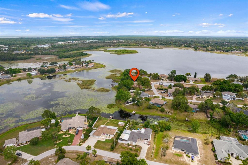 an aerial view of ocean and residential houses with outdoor space