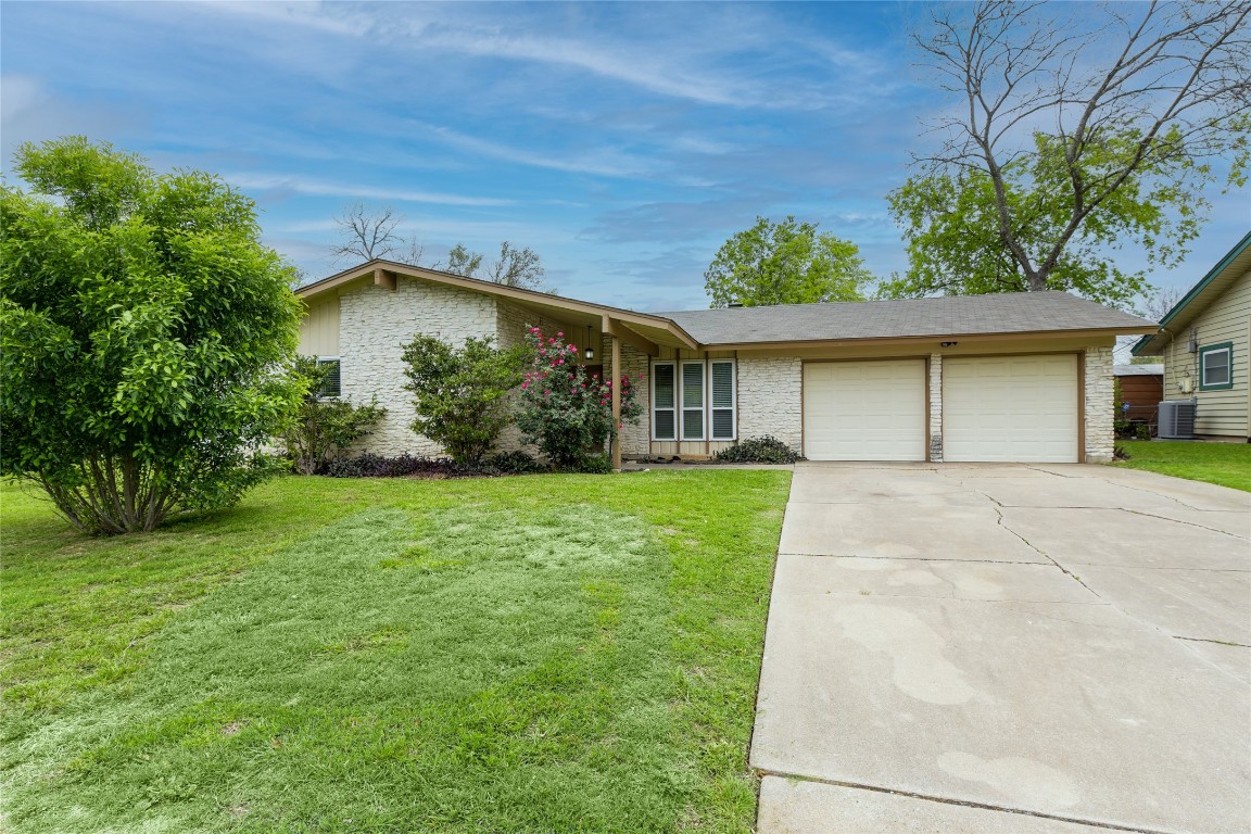 a front view of a house with a yard and potted plants