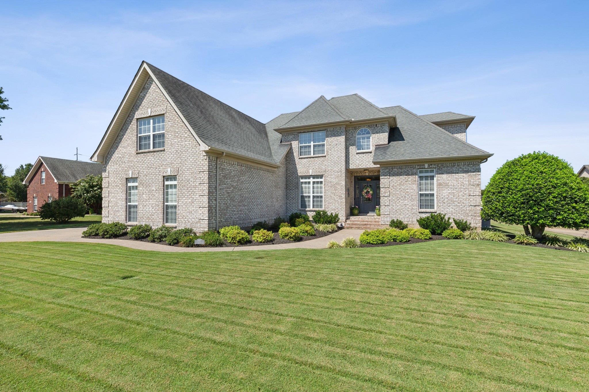 a front view of a house with a garden and yard