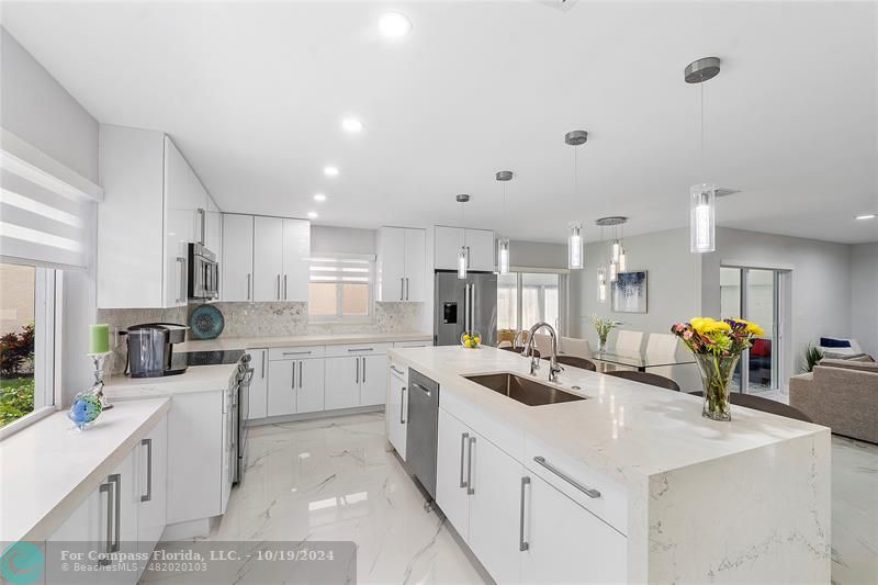 a kitchen that has a lot of cabinets a sink and wooden floor