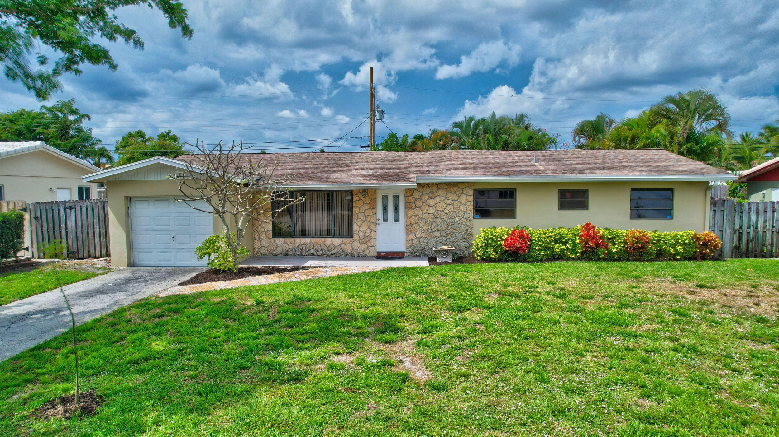 a front view of a house with a garden and plants