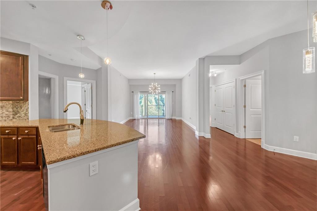 a view of kitchen island a sink wooden floor and living room view