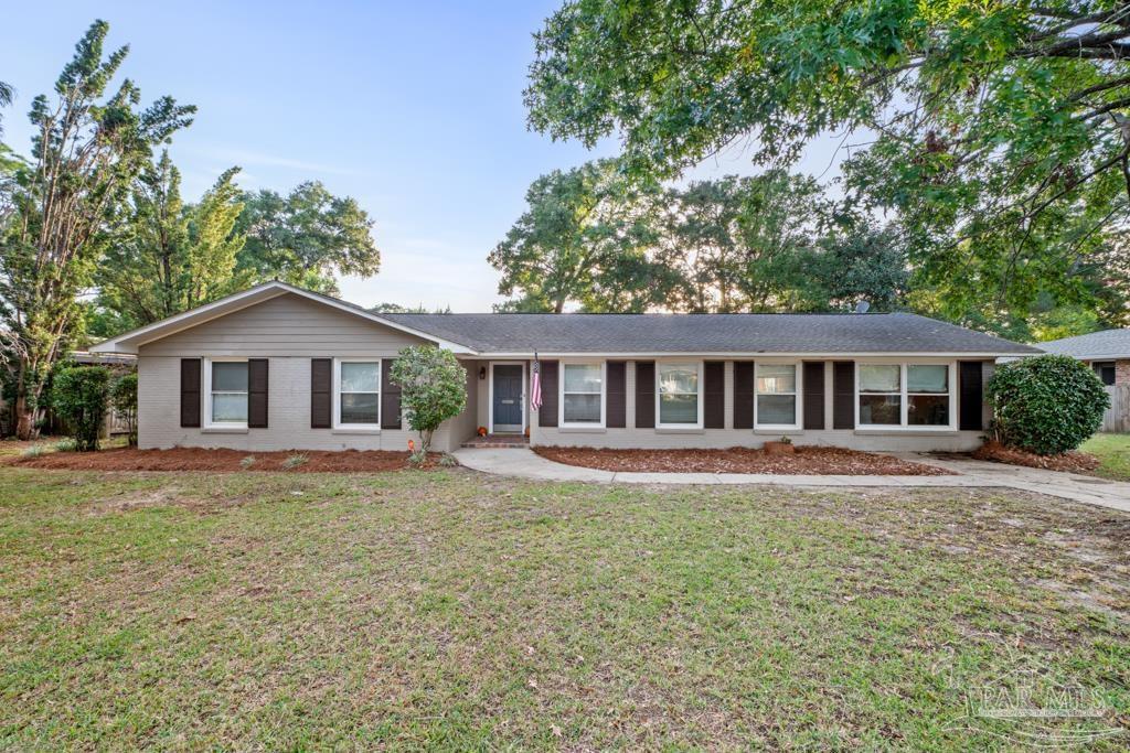 a front view of a house with yard and green space