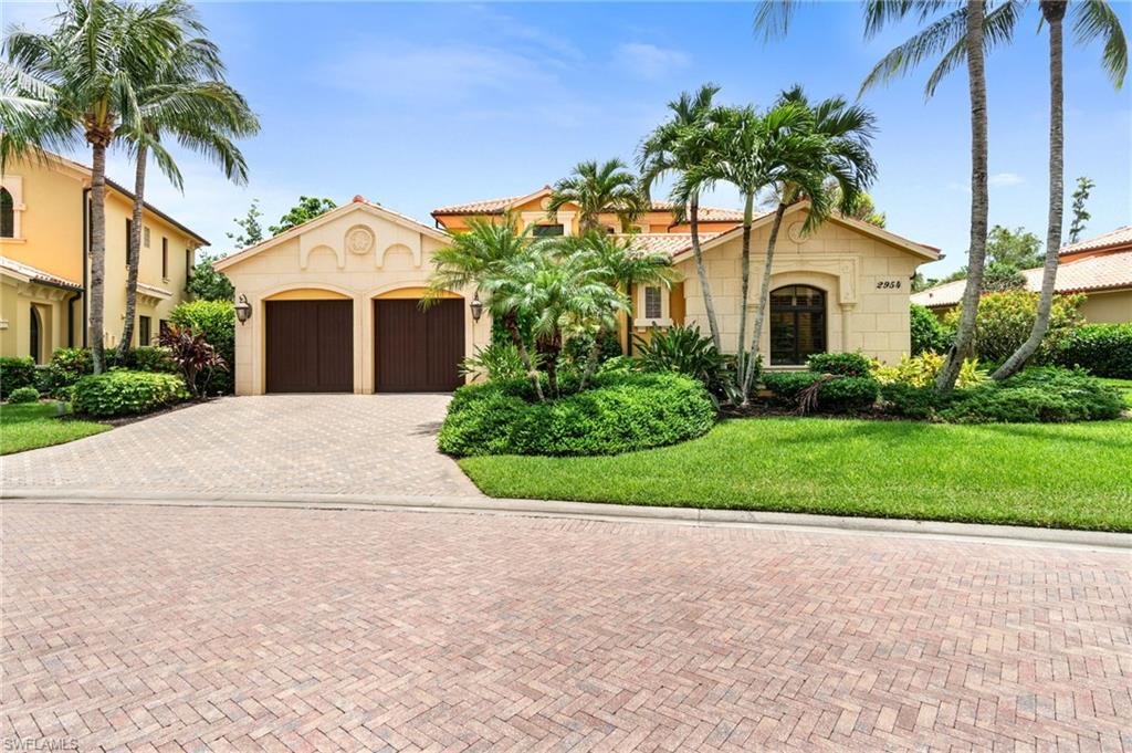 a front view of a house with a garden and palm trees