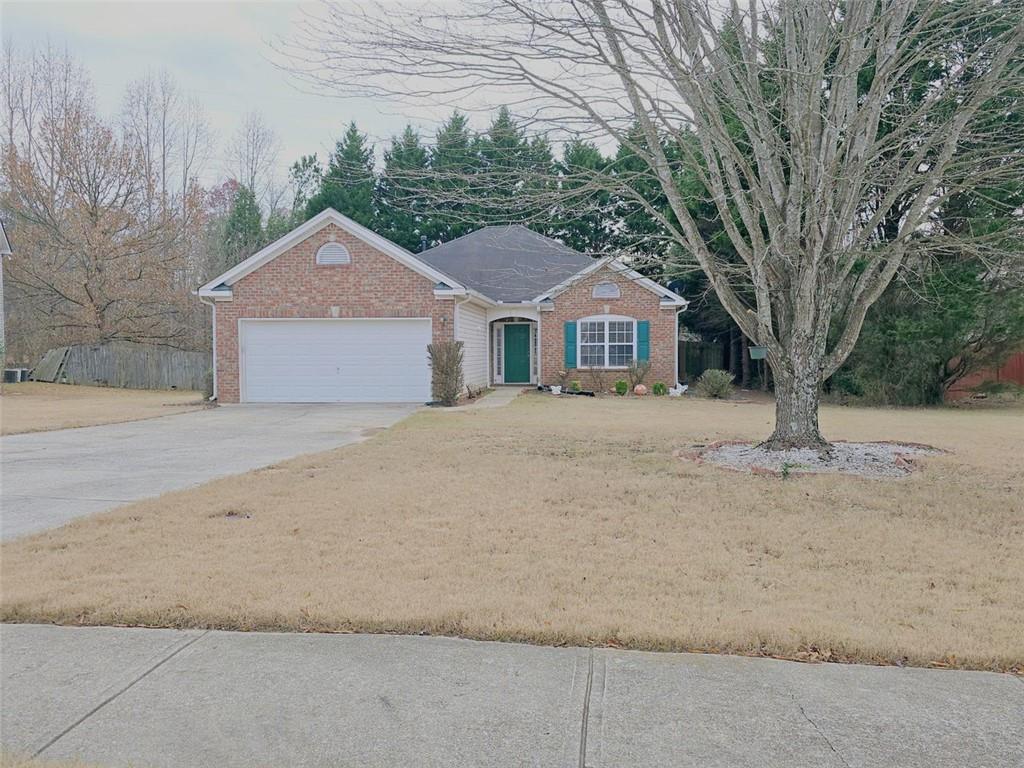 a front view of a house with a yard and large trees