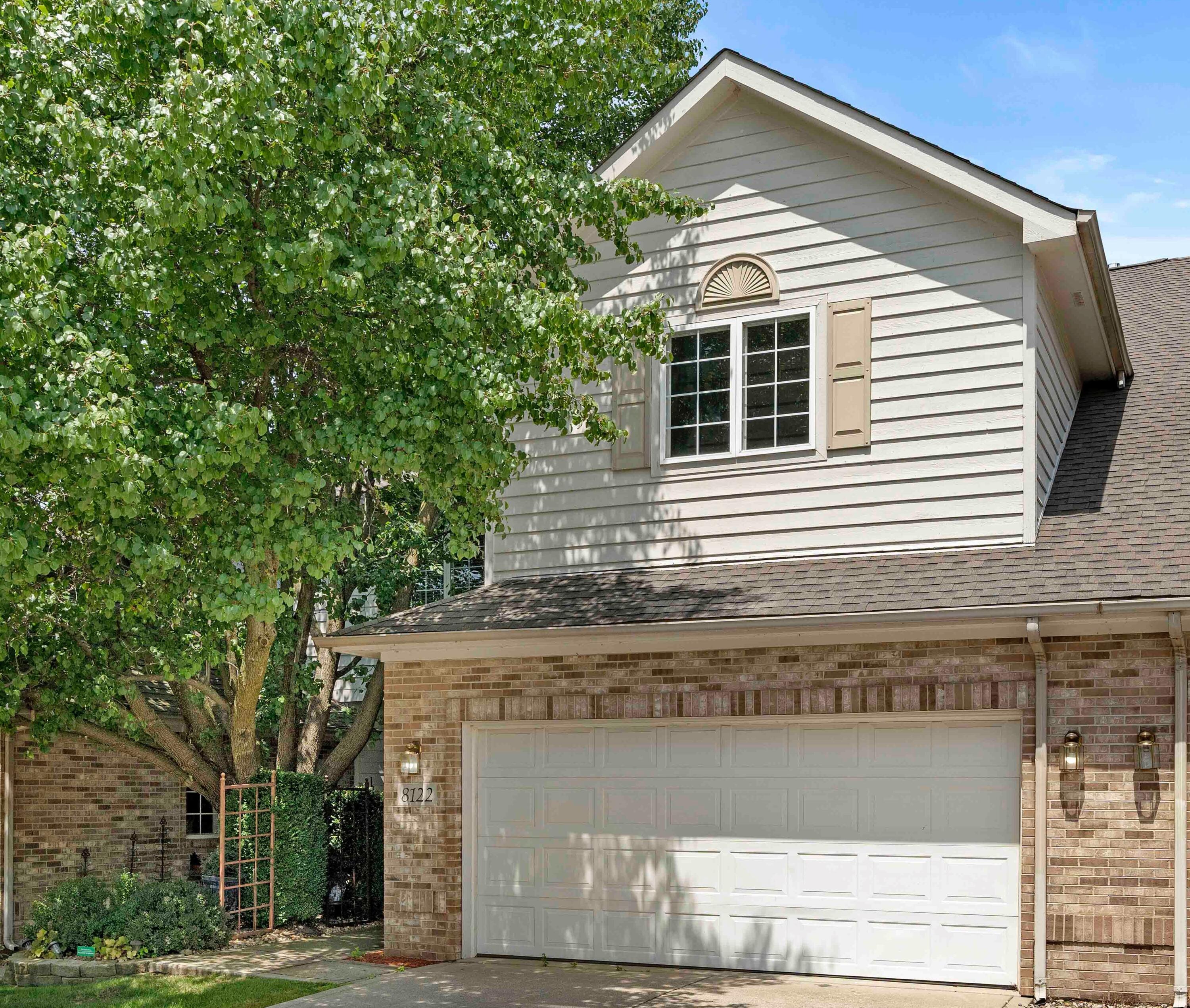 a front view of a house with a tree