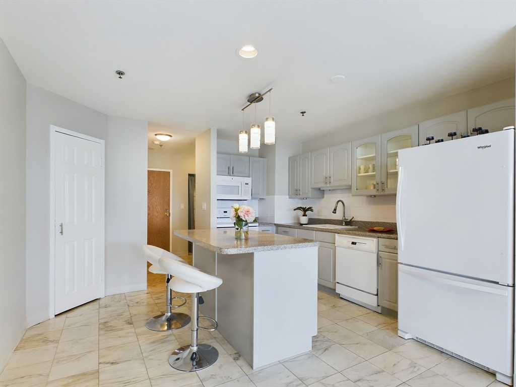 a kitchen with refrigerator and chairs