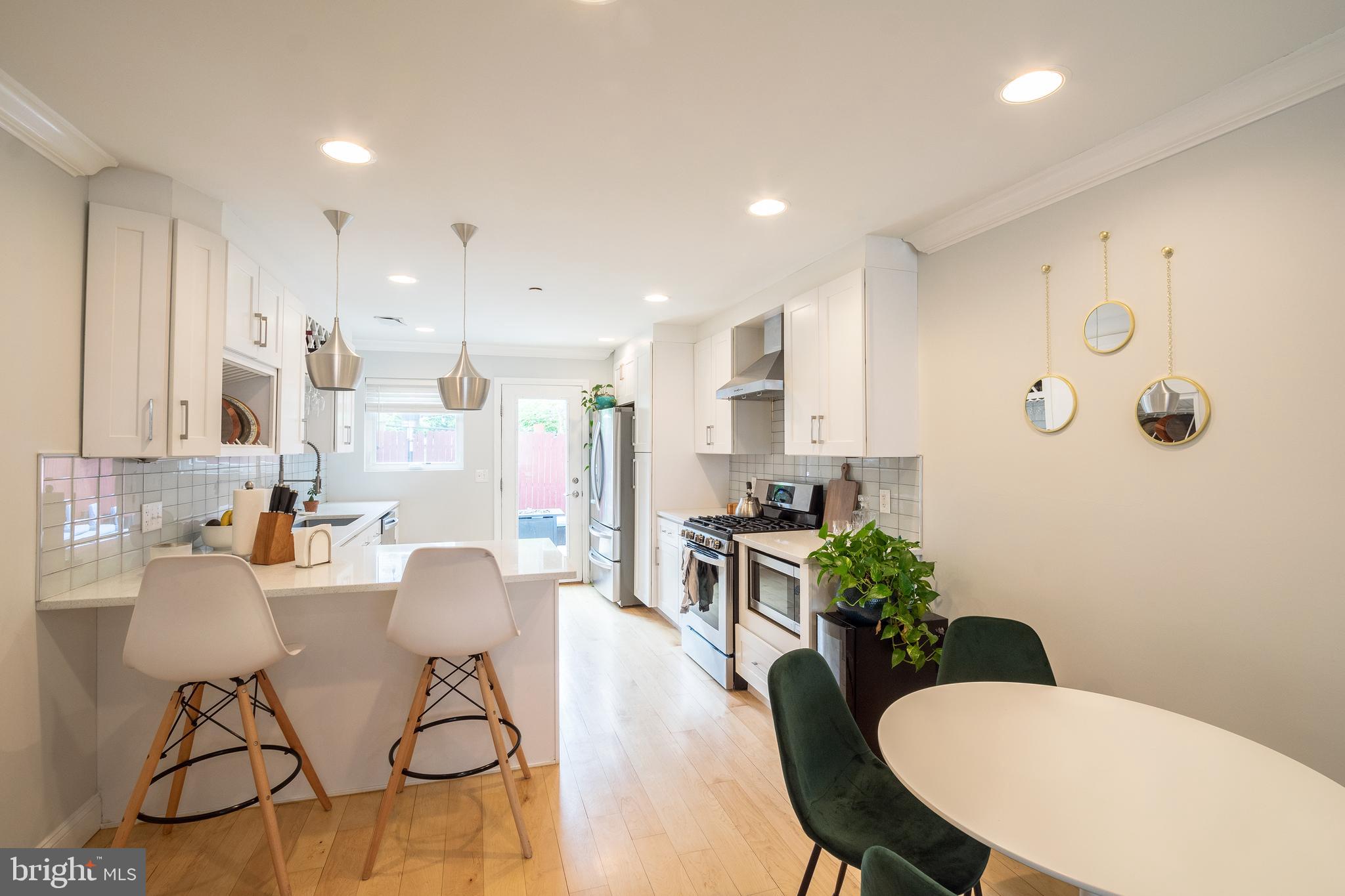 a kitchen with stainless steel appliances a table and chairs in it