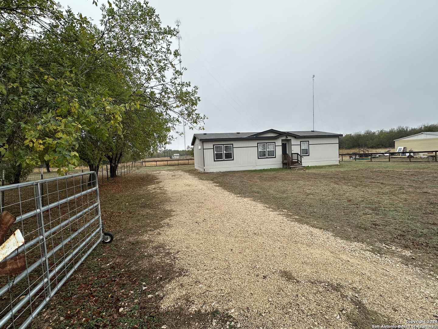 a view of a yard with wooden fence