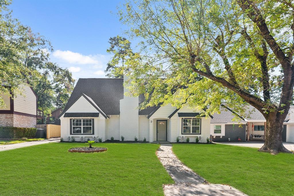 a front view of a house with a yard and trees