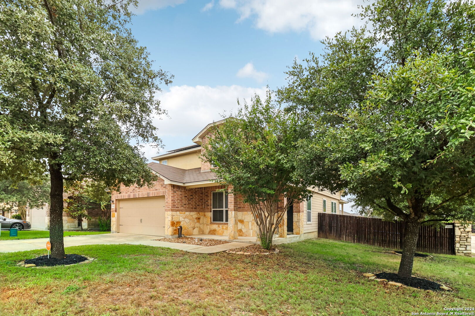 a front view of a house with a yard and trees