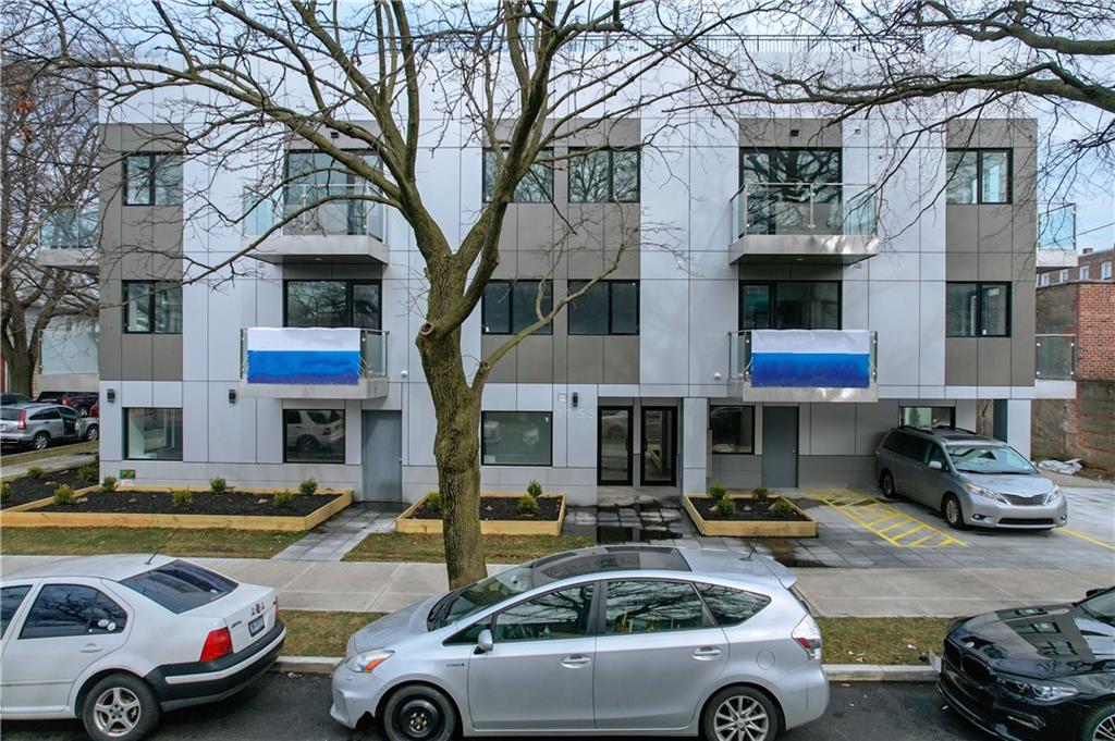 a front view of a building with cars parked