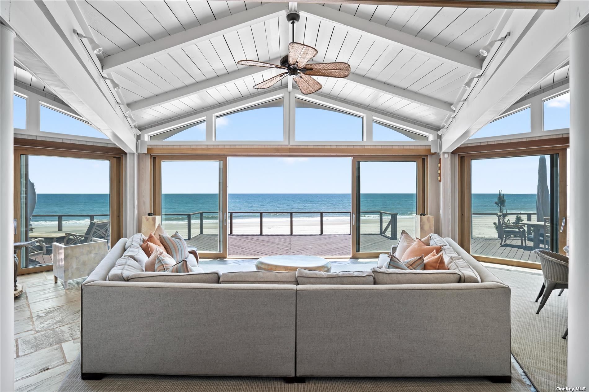 a living room with furniture and floor to ceiling windows