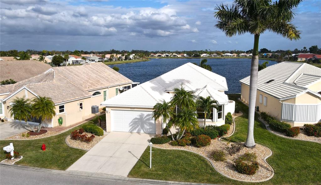 an aerial view of a house with a yard and lake view