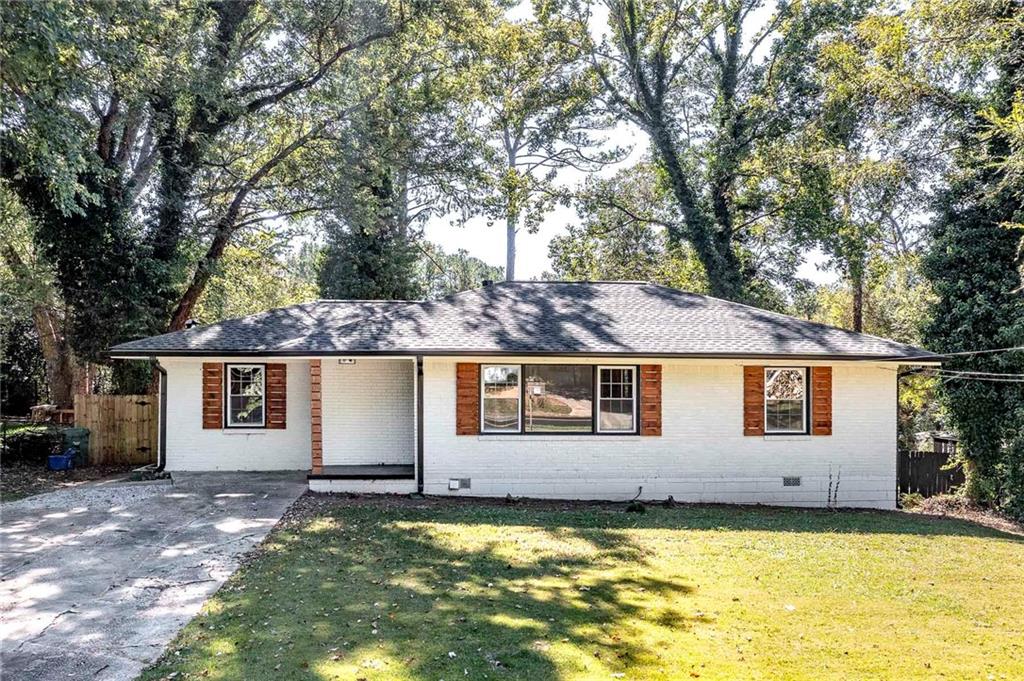 a view of a house with a backyard and a tree