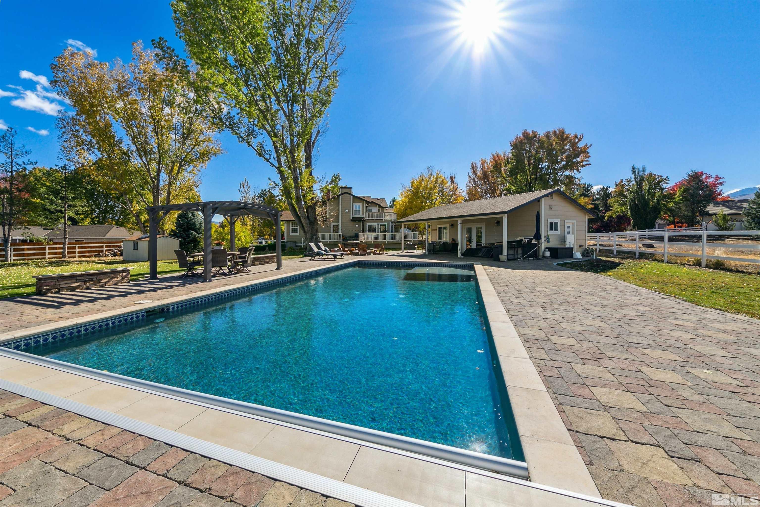 a view of swimming pool with outdoor seating and a garden