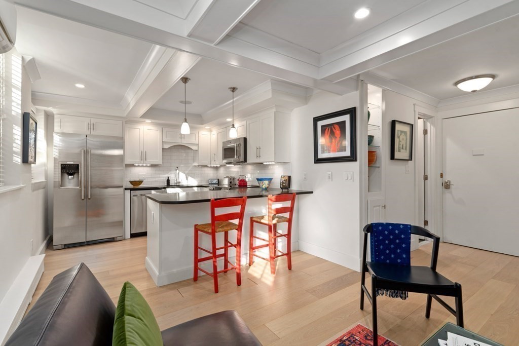 a living room with stainless steel appliances kitchen island granite countertop furniture and a dining table with kitchen view