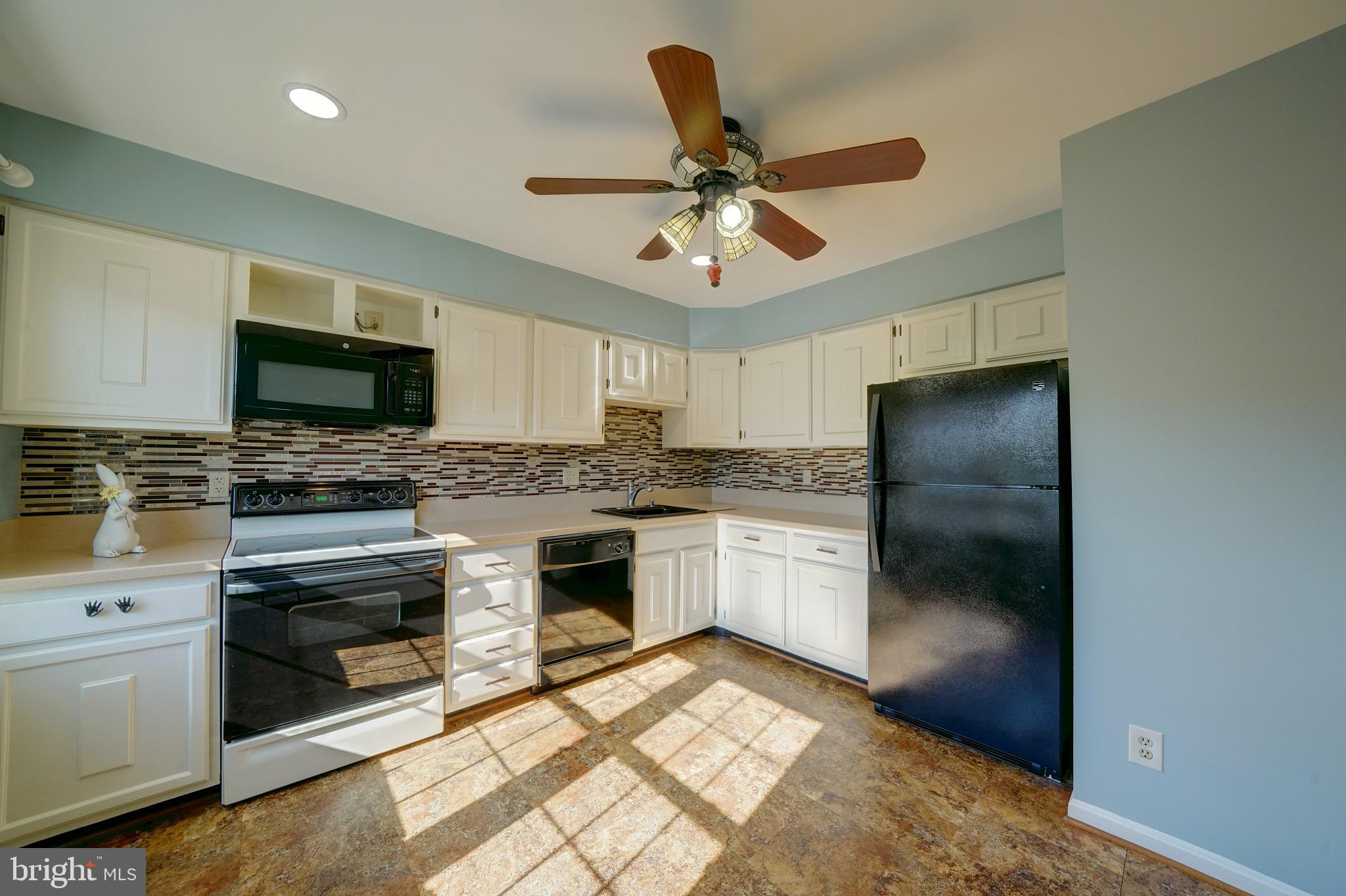 a kitchen with a refrigerator and a stove top oven