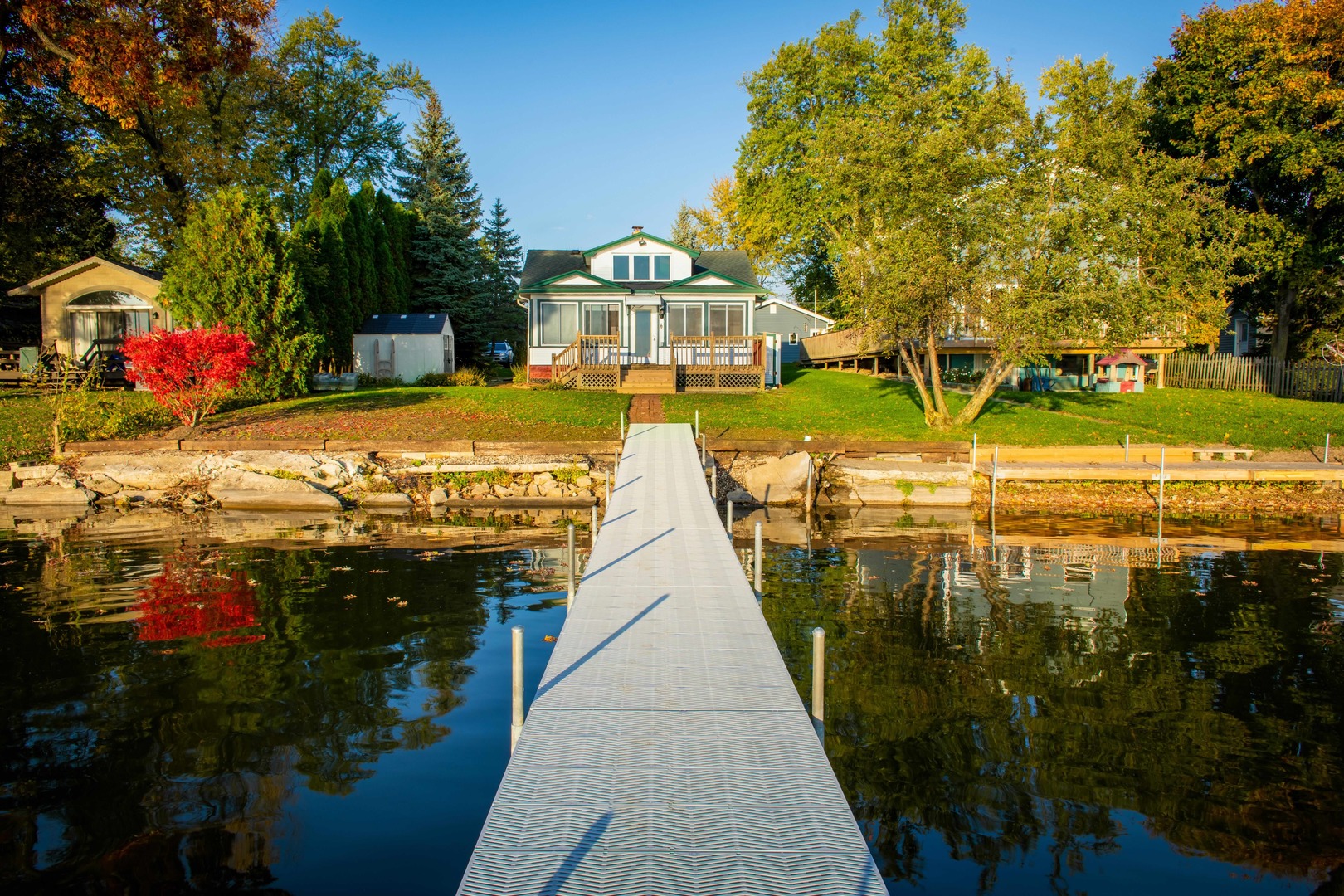 a view of swimming pool with outdoor seating and trees in the background