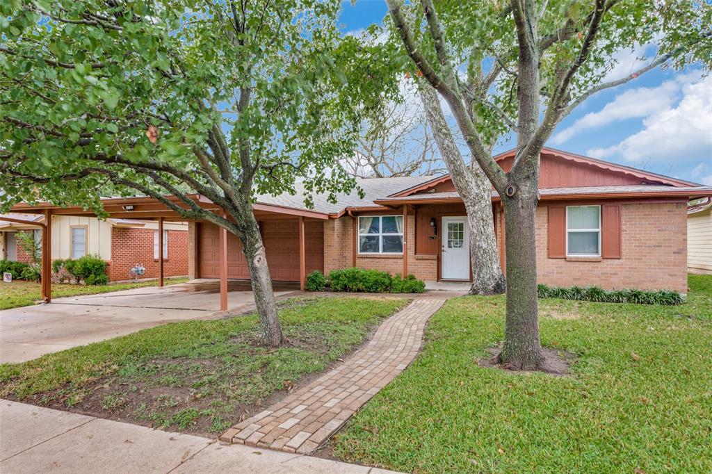 a front view of a house with a yard and an tree