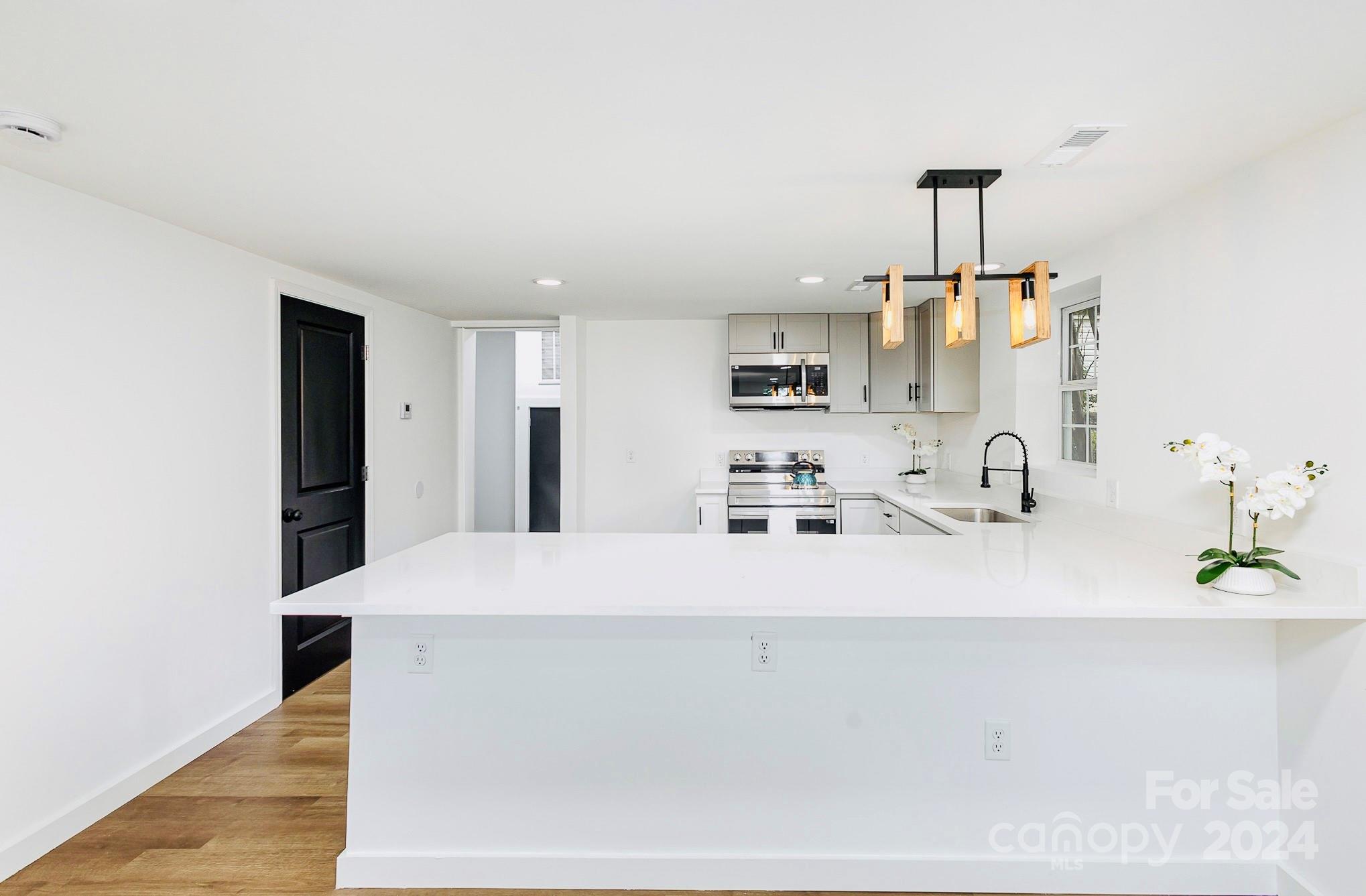 a view of kitchen with stainless steel appliances granite countertop refrigerator sink and stove