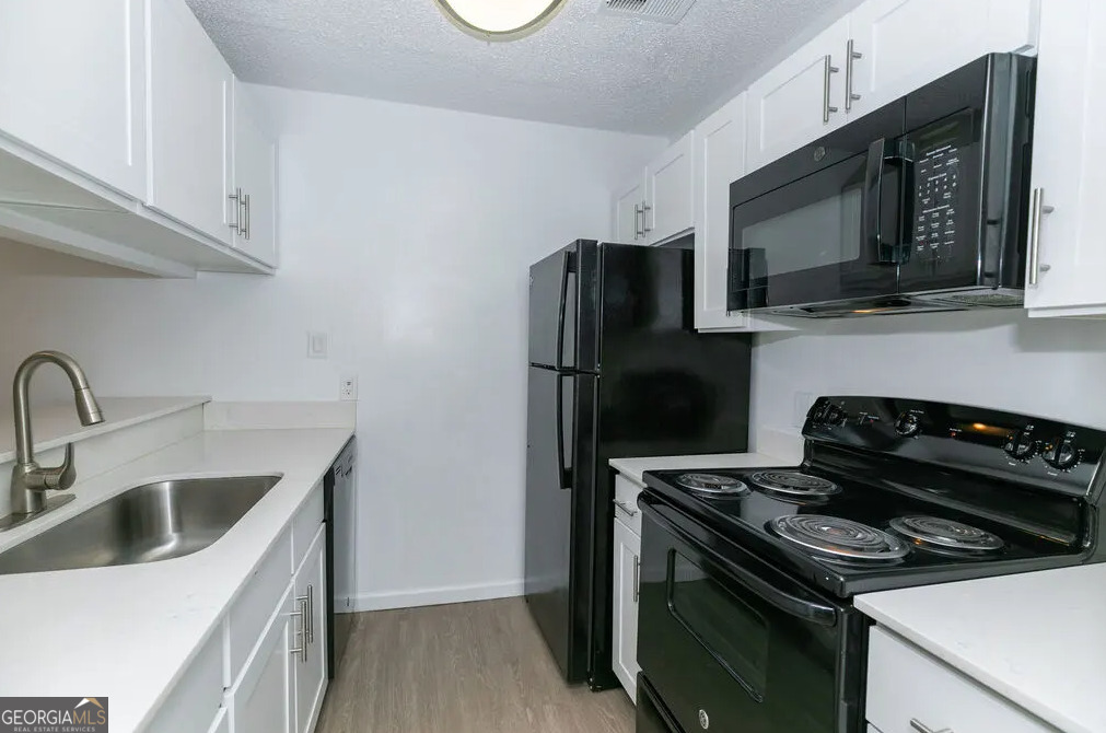 a kitchen with a stove microwave and sink