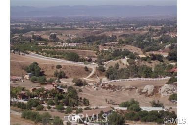 an aerial view of house with yard and mountain view in back