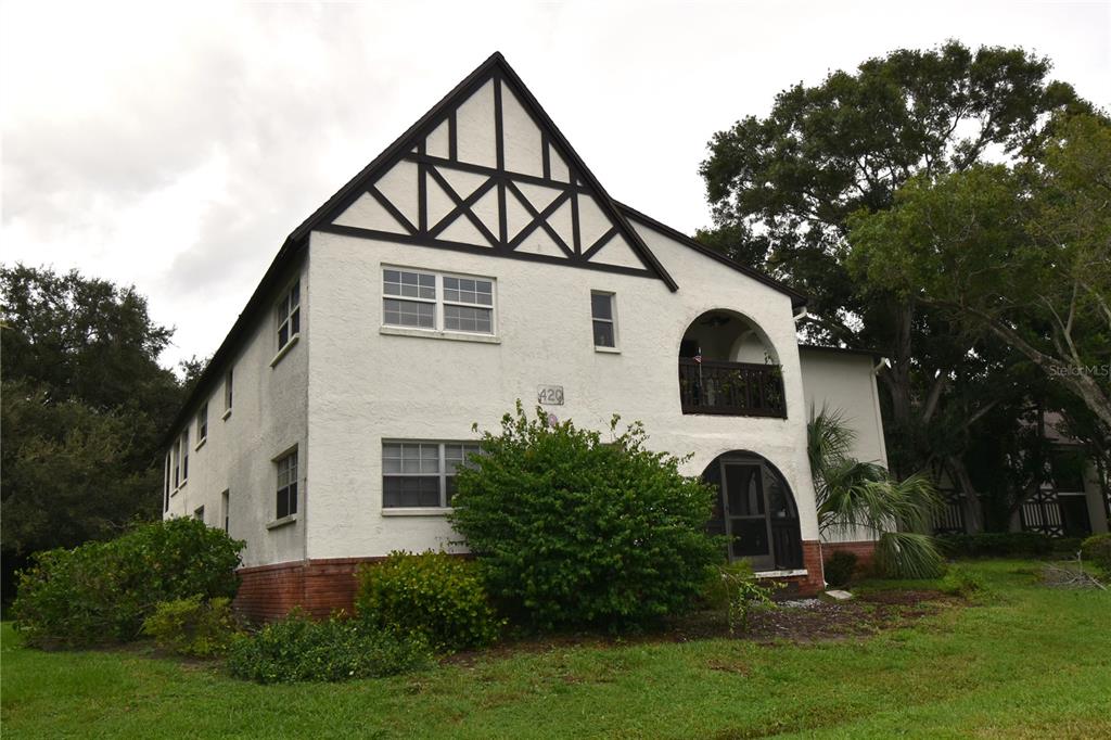 a front view of a house with a yard garage and trees