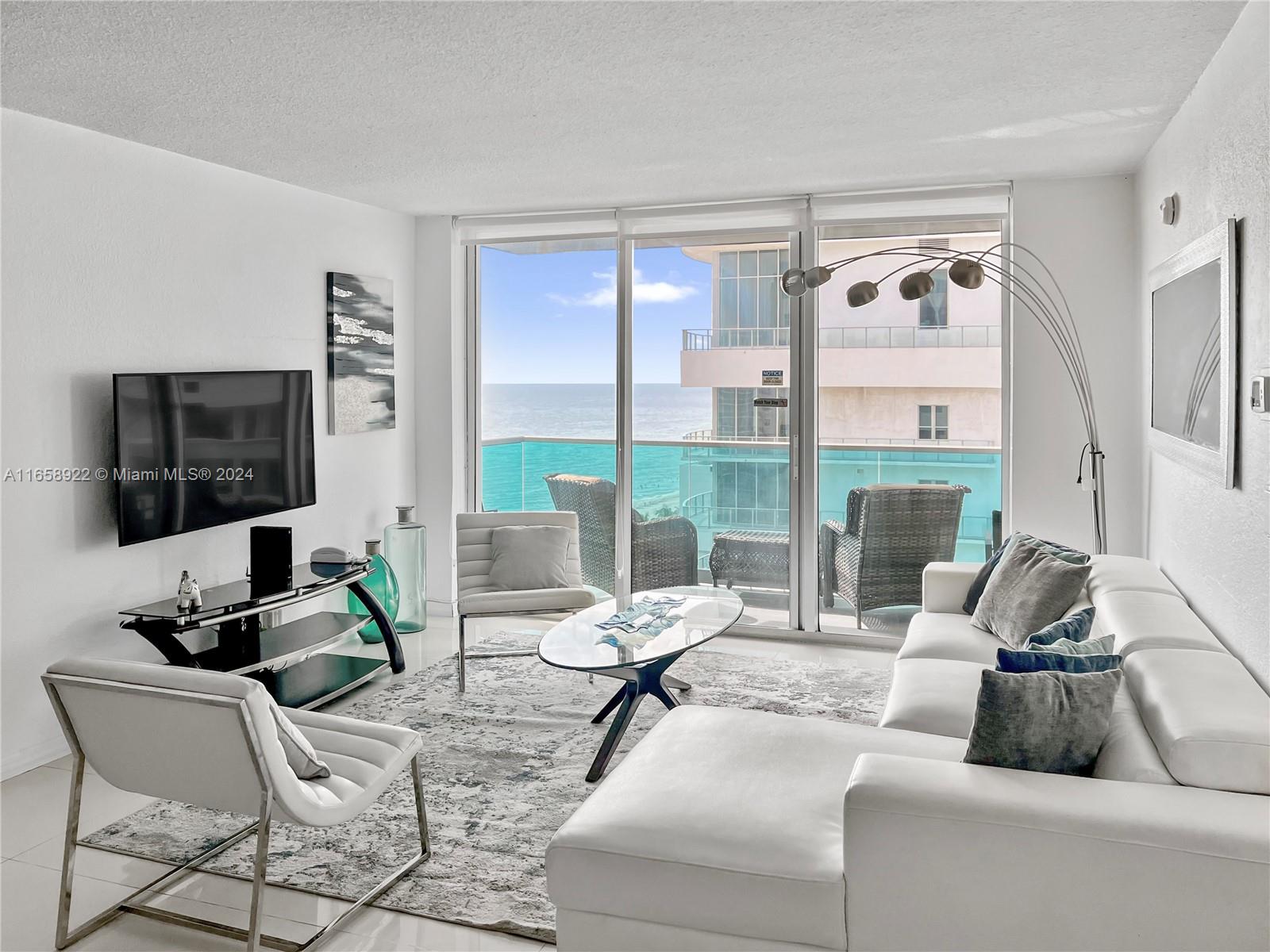 a living room with furniture a flat screen tv and a large window