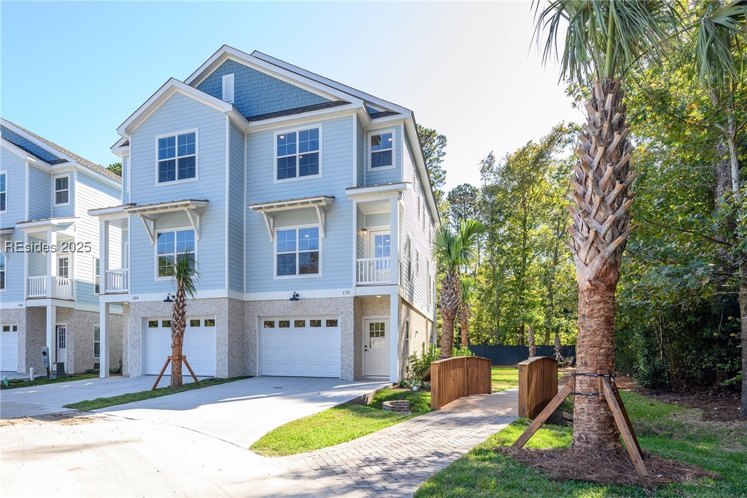 View of front of townhomes with a garage & trail l