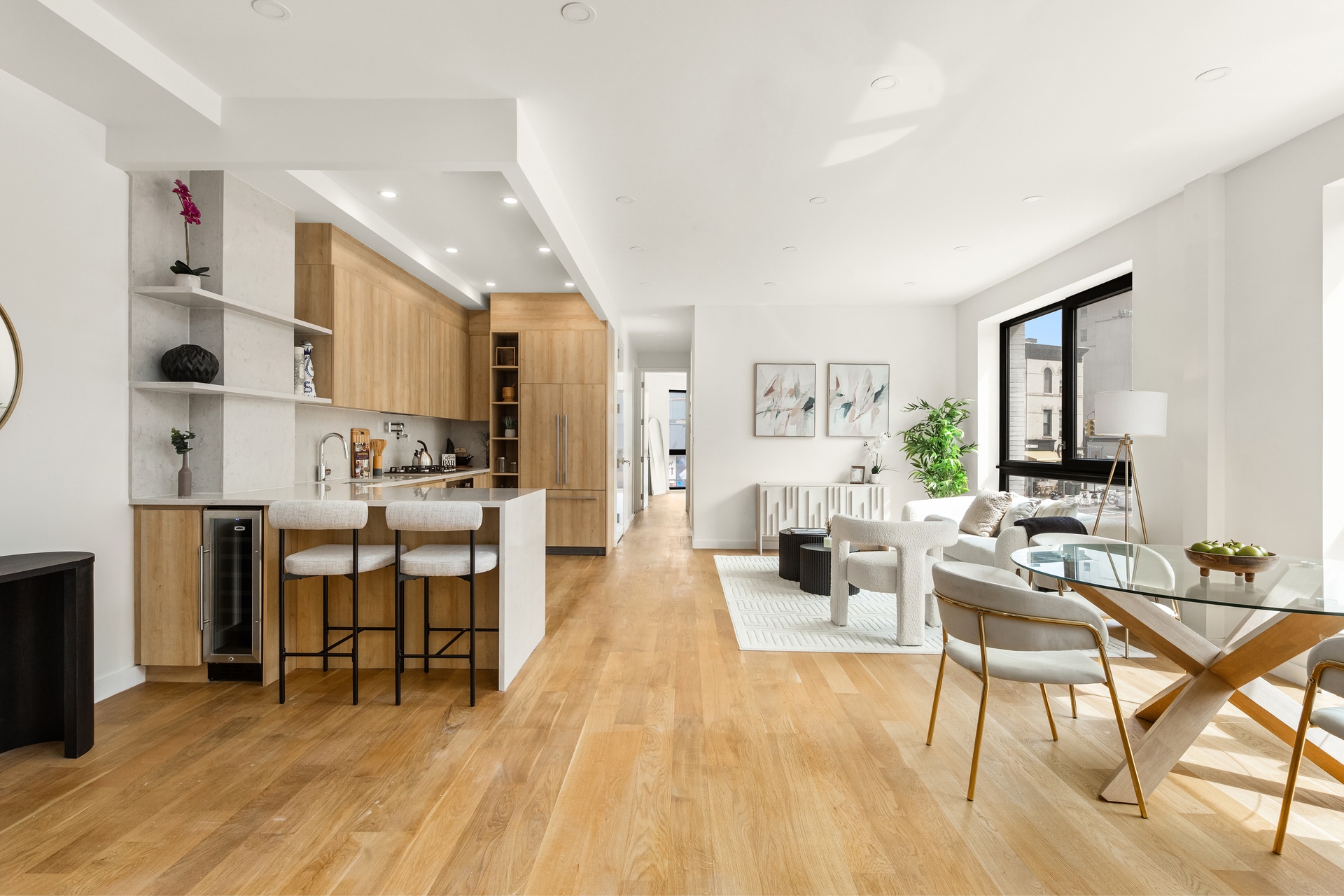 a living room with stainless steel appliances kitchen island granite countertop furniture and a wooden floor