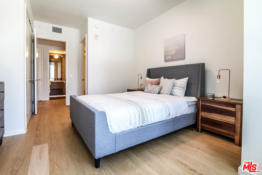 a bedroom with a bed and wooden floor