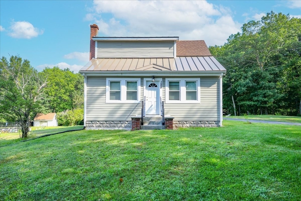 a view of a house with a yard and sitting area