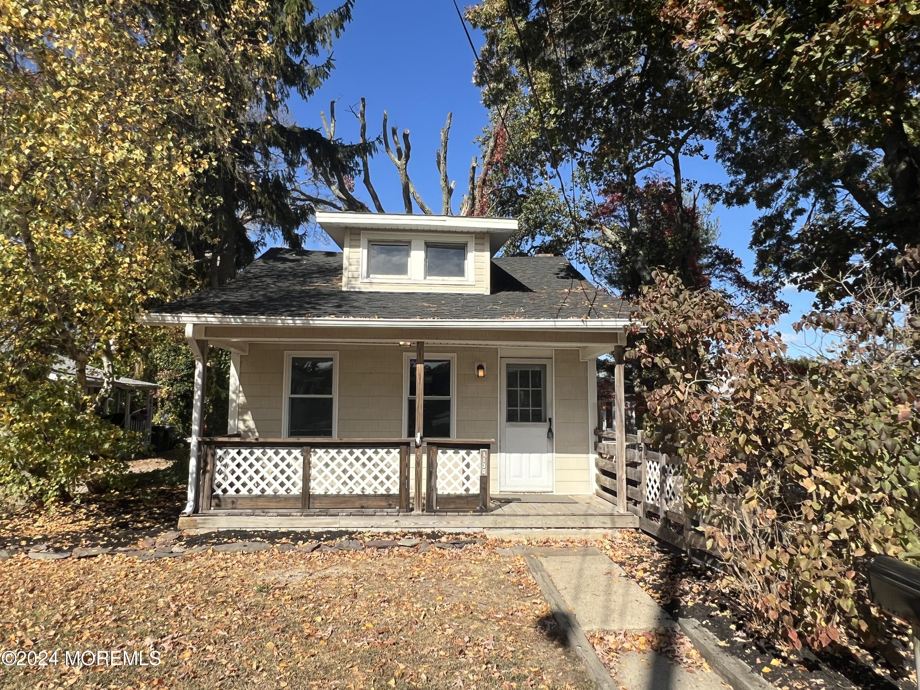 a front view of a house with a tree