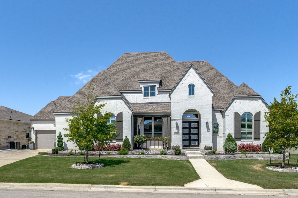 a front view of a white house with a yard