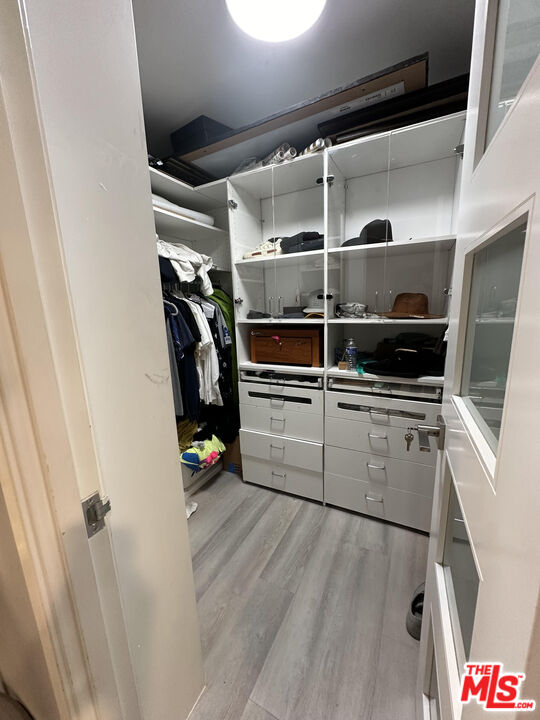 a view of walk in closet with clothes and shoes