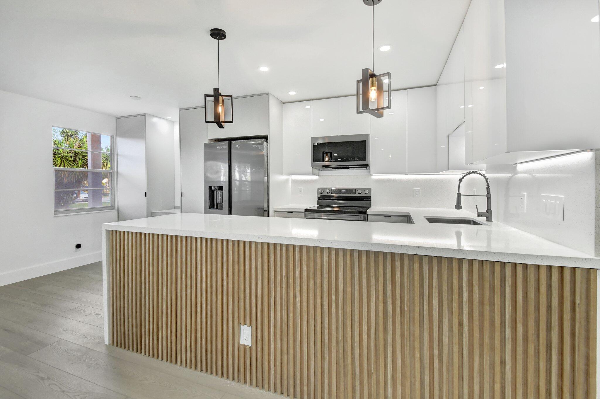 a kitchen with stainless steel appliances a sink and a refrigerator