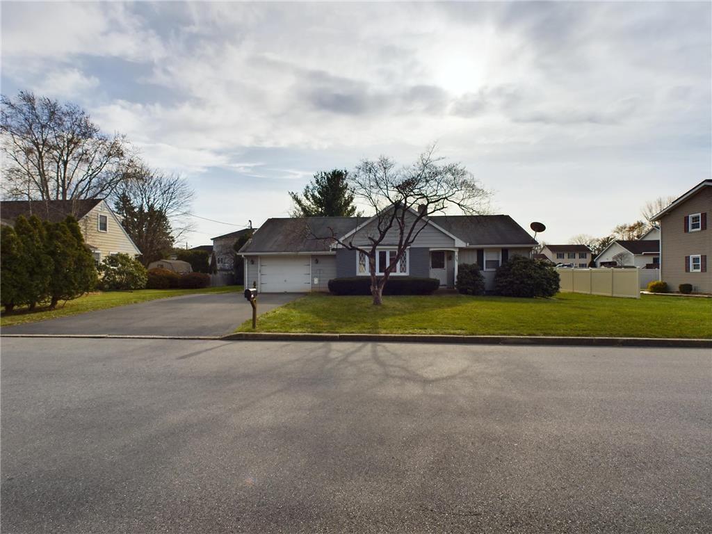 a view of a house with a big yard and large trees