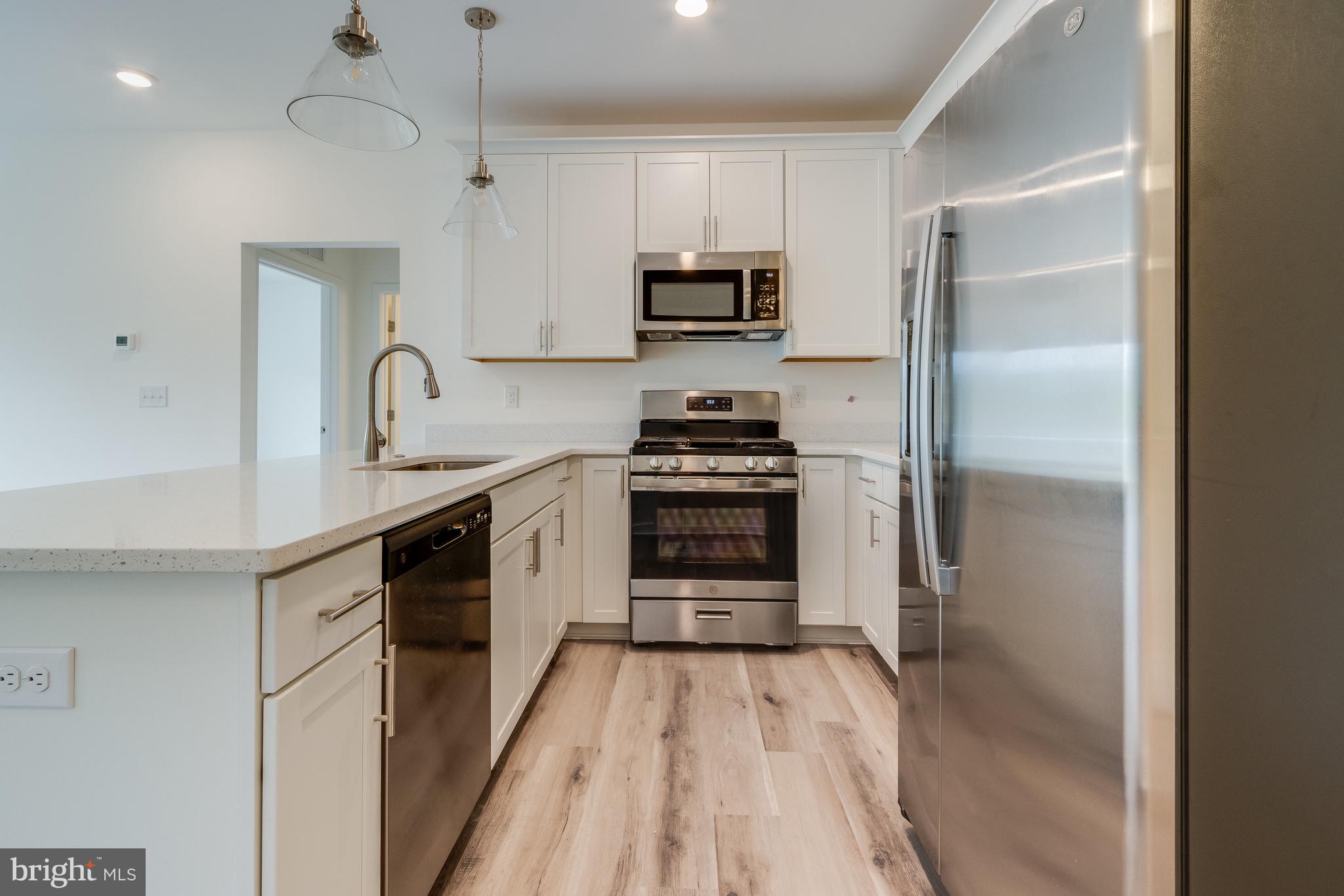 a kitchen with stainless steel appliances a refrigerator stove and microwave