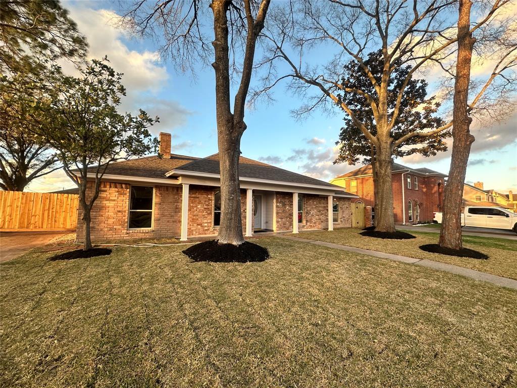 a front view of a house with a yard and trees