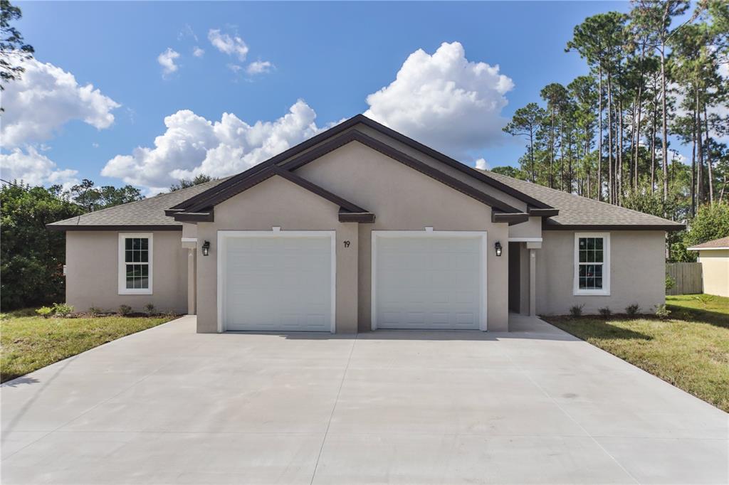 a view of a house with a yard and a garage