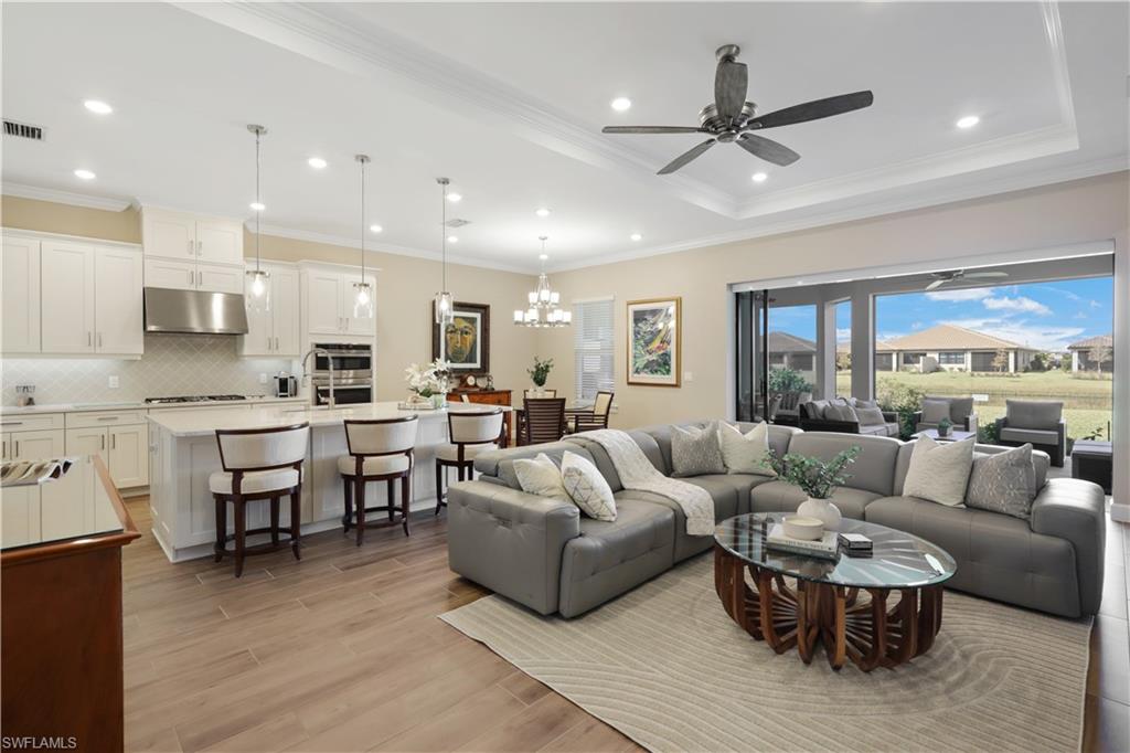 a living room with furniture kitchen view and a large window