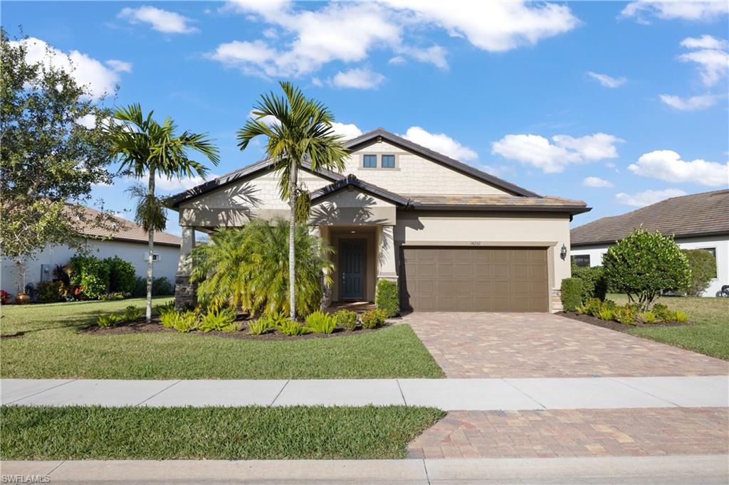 a front view of a house with a yard and trees