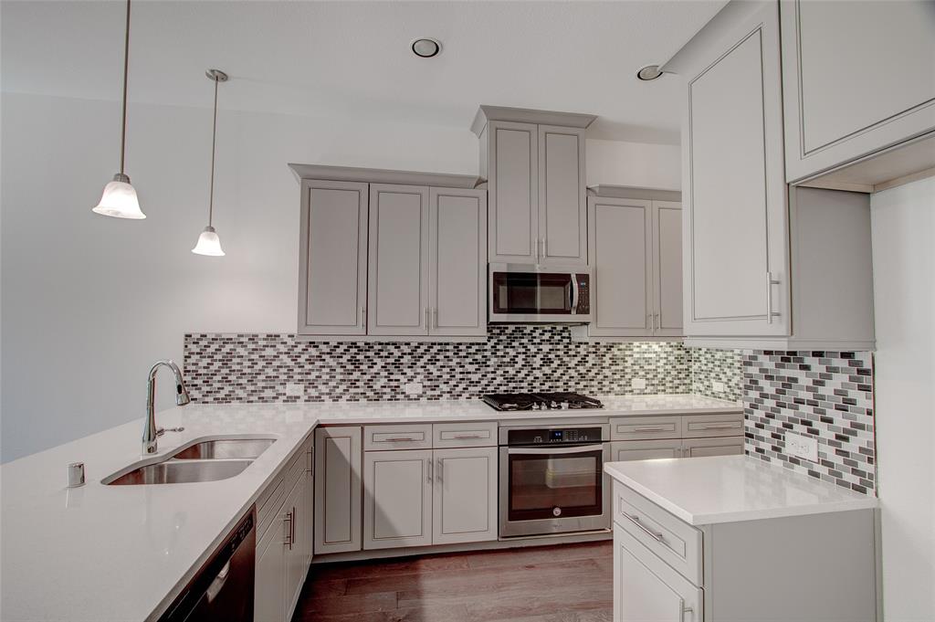 a kitchen with granite countertop a sink a stove and cabinets