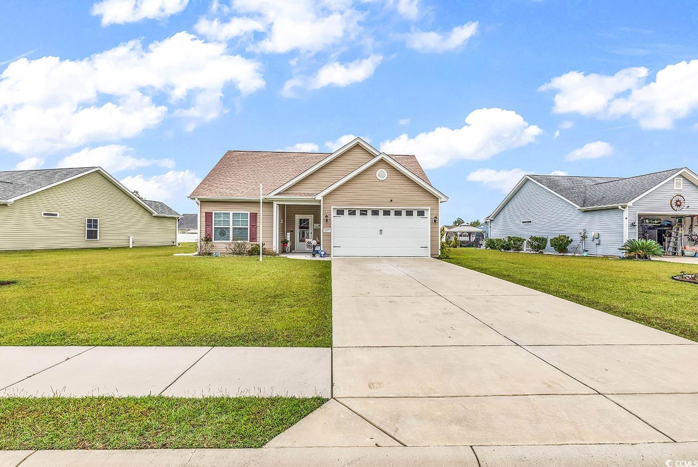 View of front of home with a front yard and a gara