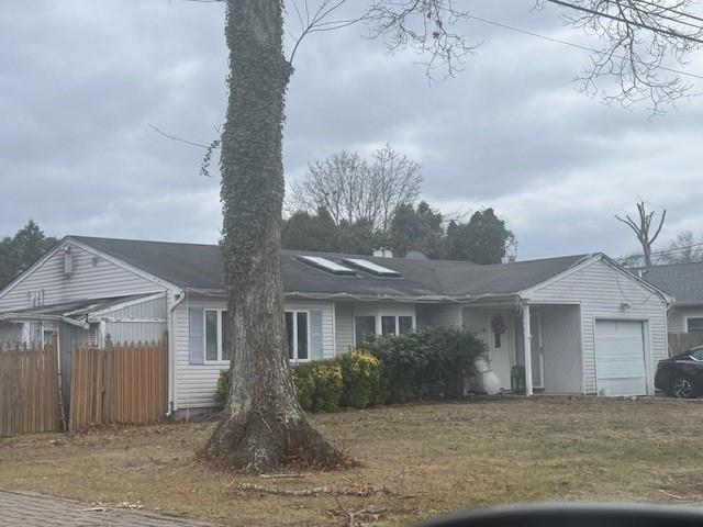 View of front of house featuring a garage and a front lawn